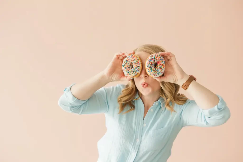 woman holding two doughnuts in front of her eyes